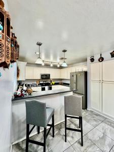 a kitchen with two chairs and a refrigerator at Cozy Private room with Shared bathroom Inside a house in Phoenix