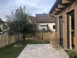 a backyard with a wooden fence and a table and chairs at Ferienwohnung Haas in Friesenheim