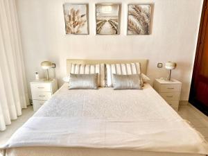 a bedroom with a large white bed with two lamps at Fuengirola Casa Centro Mar y Sol in Fuengirola