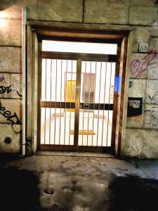 una puerta abierta en un edificio con graffiti en Casa Paolina a Metro San Paolo, en Roma