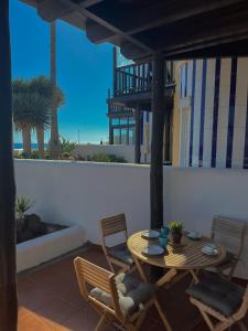Playa del AguilaにあるAmazing Apartment Altamar 2の海の景色を望むパティオ(テーブル、椅子付)