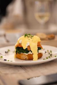 a sandwich with cheese on a plate on a table at The White Knight Premium Boutique Hotel in Għajnsielem