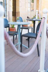 a couple of tables and chairs on a patio at The White Knight Premium Boutique Hotel in Għajnsielem