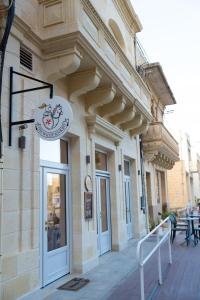 a building with a sign on the side of it at The White Knight Premium Boutique Hotel in Għajnsielem