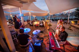 a group of people playing music on the beach at Camping Bunculuka in Baška