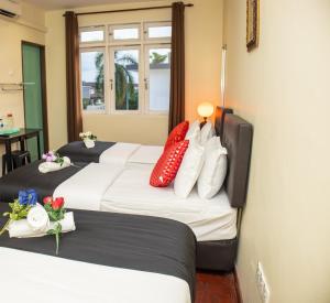 un grupo de 4 camas en una habitación de hotel en Sweet Inn Guest House en Kuantan