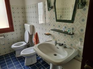 a bathroom with a sink and a toilet and a mirror at Villetta con ampio giardino in Montepiano +10 photos