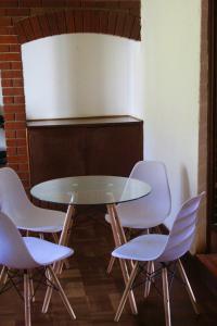 a glass table with four white chairs around it at Lovely 4 bed in Mutare - 2178 in Umtali