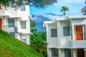 un bâtiment sur une colline avec un palmier en arrière-plan dans l'établissement Winter Note Resorts, à Munnar