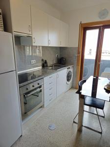 uma cozinha com um fogão, um lavatório e uma mesa em Studio no centro do Funchal em Funchal