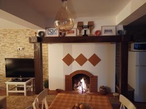 a fireplace in a living room with a table and a fire place at Refugio do Alviela in Amiães de Baixo