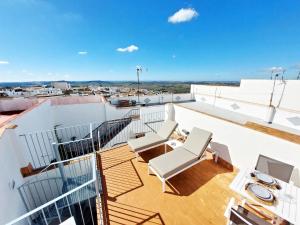 a balcony with two chairs and a table on a roof at Casita de la Suerte in Medina Sidonia