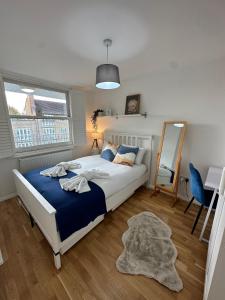 een slaapkamer met een groot bed en een spiegel bij Stoke Newington Deluxe Flat in Londen