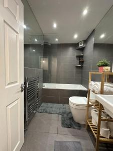 a bathroom with a tub and a toilet and a sink at Stoke Newington Deluxe Flat in London