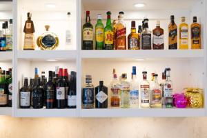 a cabinet filled with lots of bottles of alcohol at The White Knight Premium Boutique Hotel in Għajnsielem