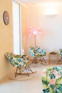 a room with two chairs and a plant in the corner at The White Knight Premium Boutique Hotel in Għajnsielem