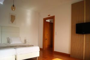 um quarto com uma cama e uma televisão de ecrã plano em Studio no centro do Funchal no Funchal