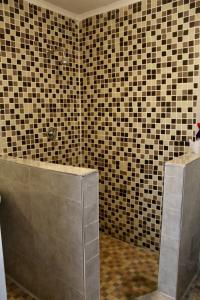 baño con bañera y pared de azulejos en 2 bedroomed house with a lovely garden - 2177 en Umtali