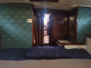 a bedroom with a bed and a mirror and a door at Voilier-péniche guinguette in Port-Louis