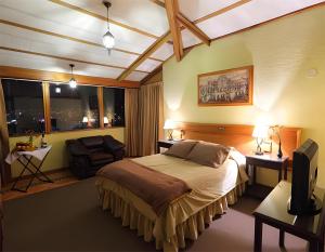sypialnia z łóżkiem, krzesłem i oknami w obiekcie Hotel El Puma w Cuzco