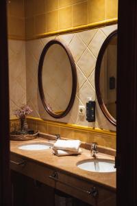 a bathroom with two sinks and two mirrors at San Sebastián DOT Rooms in San Sebastián