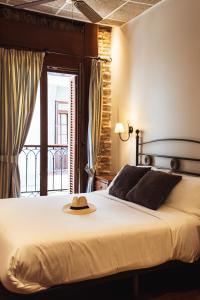 a bedroom with a bed with a hat on it at San Sebastián DOT Rooms in San Sebastián