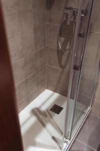 baño con ducha y puerta de cristal en San Sebastián DOT Rooms, en San Sebastián