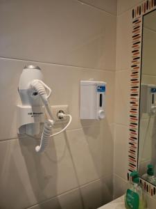 a bathroom with a white blow dryer on the wall at Junção - Apartamentos Completos in Miranda do Douro +141 photos