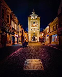 uma rua vazia com um grande edifício com uma torre de relógio em Pension Kotva em Beroun