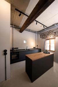特里騰海姆的住宿－Klara Rooms，一间厨房,内设黑色柜台和一张桌子