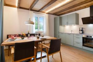 a kitchen with a wooden table with chairs and a dining room at Landluft Ferien - Wohnung Morgentau in Heiligenberg