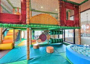 a play room with a play structure with a slide at Wild Rose Holiday Park in Colby
