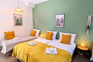 2 camas en una habitación con paredes amarillas y verdes en Uhlpartment - im Herzen von Salzwedel, en Salzwedel