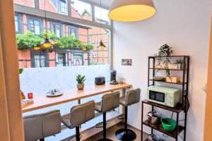 a room with a bar with chairs and a window at Uhlpartment - im Herzen von Salzwedel in Salzwedel