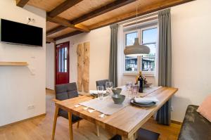 a dining room with a wooden table with chairs at Landluft Ferien - Wohnung Morgentau in Heiligenberg