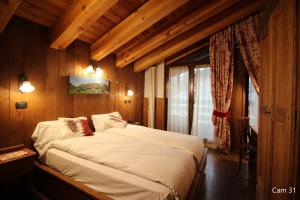 ein Schlafzimmer mit einem Bett in einem Zimmer mit Holzwänden in der Unterkunft Hotel Meynet in Breuil-Cervinia