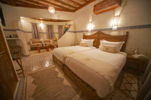 a bedroom with two beds and a living room at OZ Palace Ouarzazate & SPA in Ouarzazate +132 photos