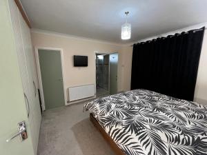 um quarto com uma cama com um edredão preto e branco em Straffan em Straffan