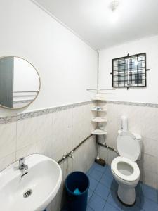 een badkamer met een wastafel, een toilet en een spiegel bij LILY HOMESTAY PUTATAN in Kota Kinabalu