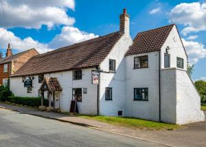 a white building on the side of a street at White Rose Country Cottages in Thormanby