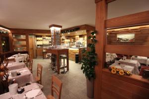 een eetkamer met tafels en stoelen in een restaurant bij Hotel Meynet in Breuil-Cervinia