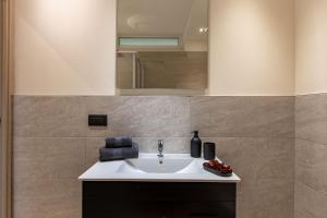 La salle de bains est pourvue d'un lavabo et d'un miroir. dans l'établissement Loft Marina, à Fossano