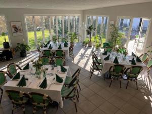 a large room with tables and chairs and windows at Dolphin Hotel Herning in Herning