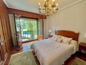 Un dormitorio con una cama grande y una lámpara de araña. en Amatxo Maitia Amplio piso en zona residencial, en Bilbao