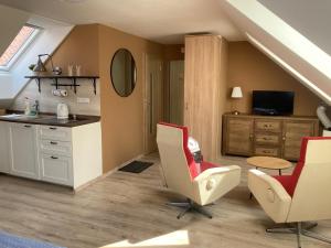 uma cozinha com 2 cadeiras, uma mesa e um lavatório em Pension Kotva em Beroun