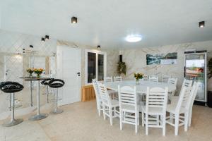 a dining room with a white table and white chairs at Casa Maramureșană Beliș in Beliş