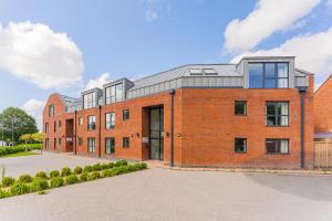 un bâtiment en briques rouges avec un toit gris dans l'établissement Stylish 2 Bedroom Apartments in Derby, à Derby