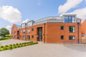 a red brick building with a gray roof at Stylish 2 Bedroom Apartments in Derby in Derby