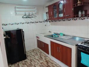 麥德林的住宿－Apartamento Buenos aires，厨房配有黑色冰箱和水槽