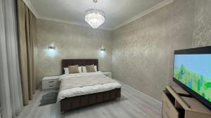 een slaapkamer met een bed en een flatscreen-tv bij Best view in city, secured 24/7 in Bisjkek